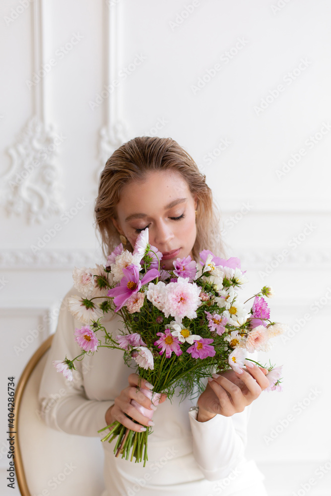 Woman in white dress holding beautiful bouquet of pink cosmos flowers. Hands with bouquet of seasonal flowers. Pink cosmos summer flowers. Wedding bouquet. Woman in white dress holding beautiful bouquet of pink cosmos flowers. Hands with bouquet of seasonal flowers. Pink cosmos summer flowers. Wedding bouquet.