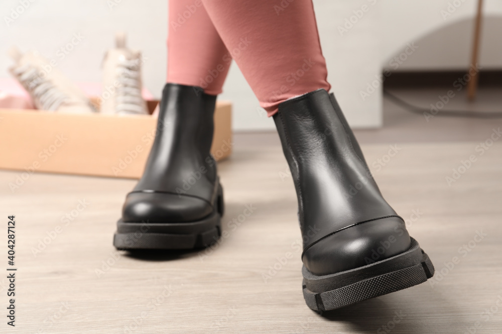 Woman wearing stylish leather boots indoors, closeup