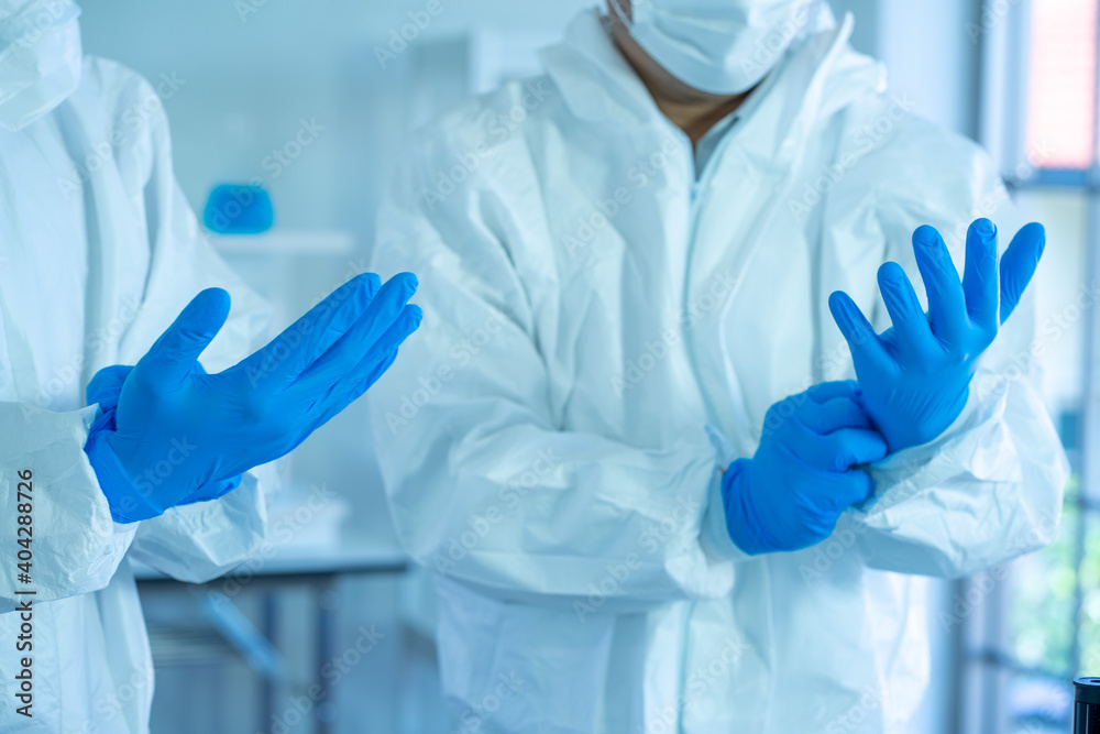 Asian medical scientists wearing PPE protective suit work n laboratory for virus pandemic vaccine Asian medical scientists wearing PPE protective suit work n laboratory for virus pandemic vaccine