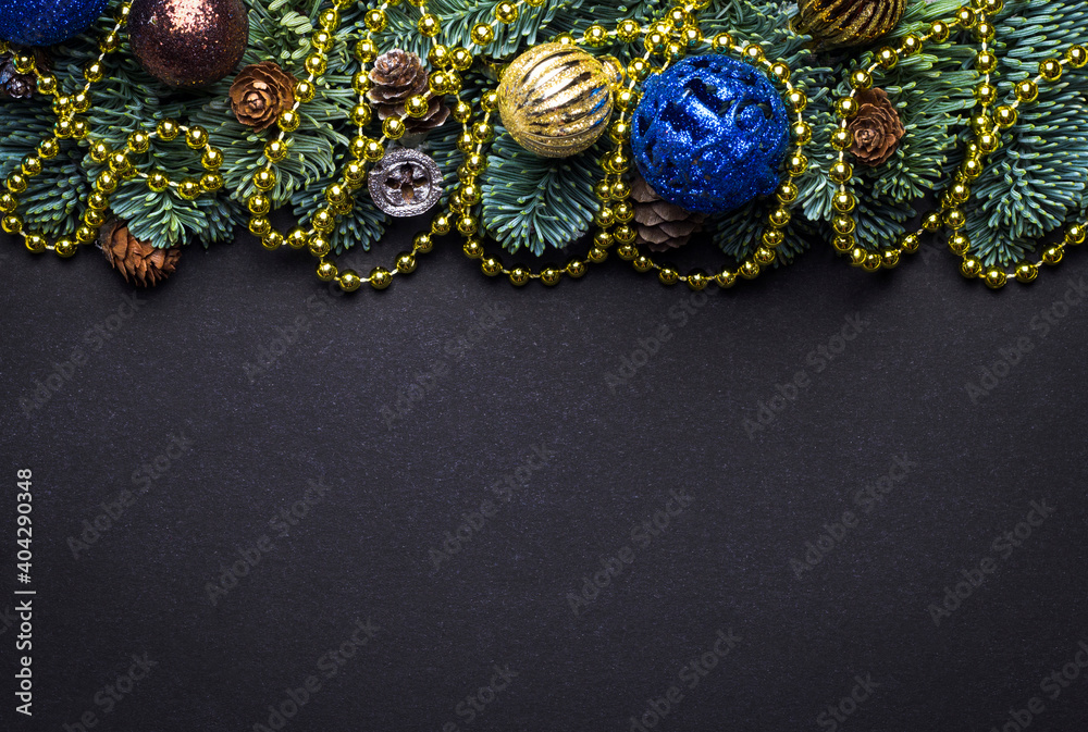 Black New Year background. Fir branches with New Year's toys and cones. Black New Year background. Fir branches with New Year's toys and cones.