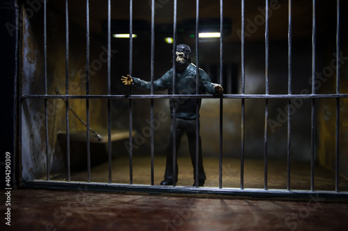 Jail or prison cell. Man in prison man behind bars concept. Old dirty grunge prison miniature. Dark prison interior creative decoration. Selective focus