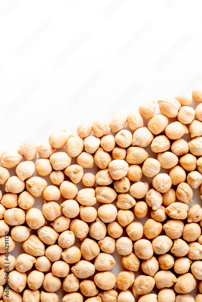 Pile of chickpeas arranged diagonally. image with copy-space and white background. Vegan food and nutrition.