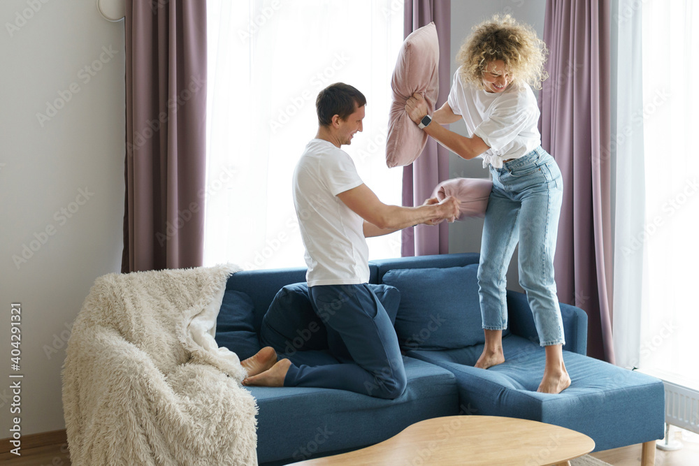 Happy couple during  pillow fight in their apartment
