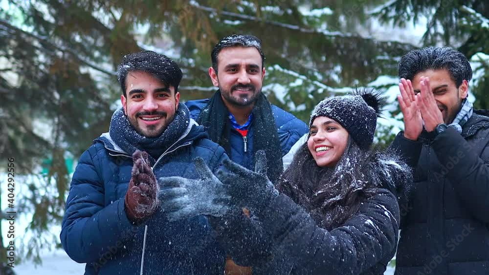 group of four indian having fun playing in snow outdoors spending Chrisymas holidays