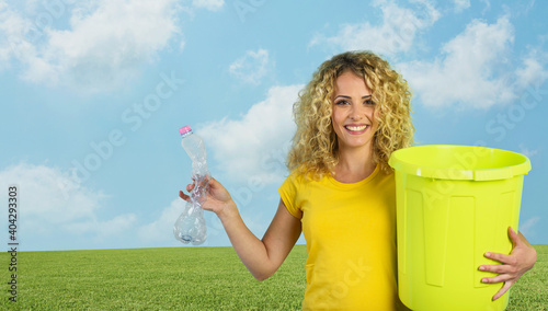 Woman is ready to puts a plastic bottle in the garbage can. photo