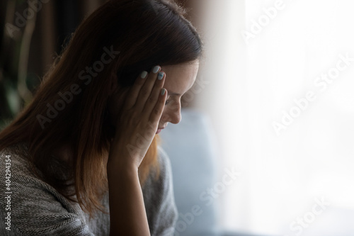 Close up of unhappy young Caucasian woman feel stressed lonely at home, thinking pondering of life personal problems. Upset sad millennial female distressed with breakup. Loneliness, solitude concept.