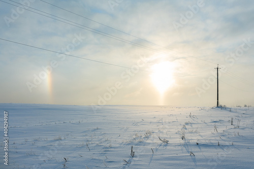 Sunrise and halo phenomena on a winter morning in a snowy field
