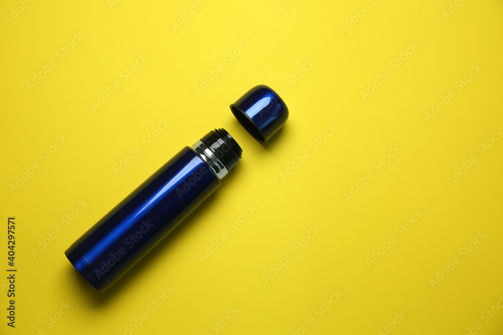 New modern thermos and cup on yellow background, flat lay. Space for text New modern thermos and cup on yellow background, flat lay. Space for text