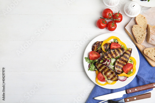 Delicious salad with roasted eggplant served on white wooden table, flat lay. Space for text