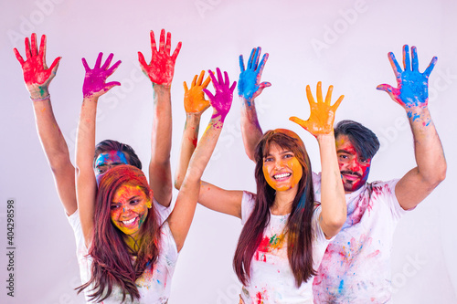 four happy best friends having great traditional holi time together in white background studio