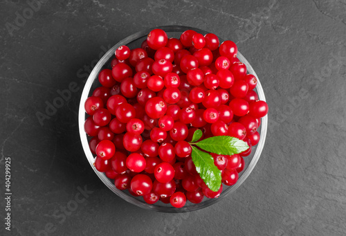 Fresh cranberry in bowl on dark grey table, top view
