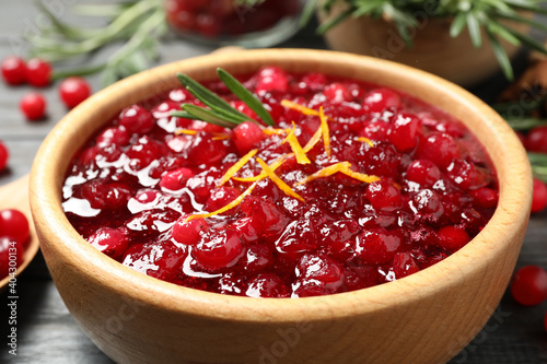 Fresh cranberry sauce with orange peel and rosemary in bowl, closeup