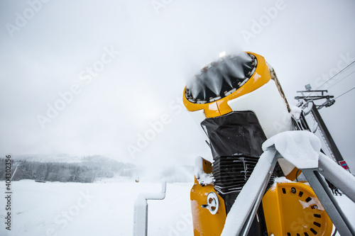 Snow cannon, machine or gun snowing the slopes or mountain for skiers ans snowboarders, artificial snow © Khaligo