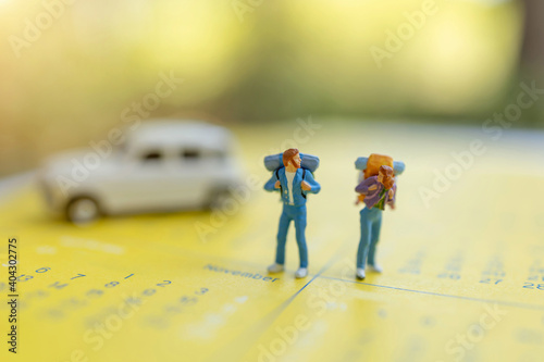 Miniature people: Traveler with a backpack standing on calendar, Travel and vacation Concepts.