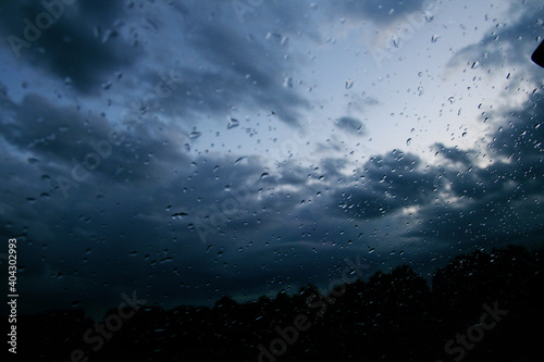Sky with clouds through the glass with water drops