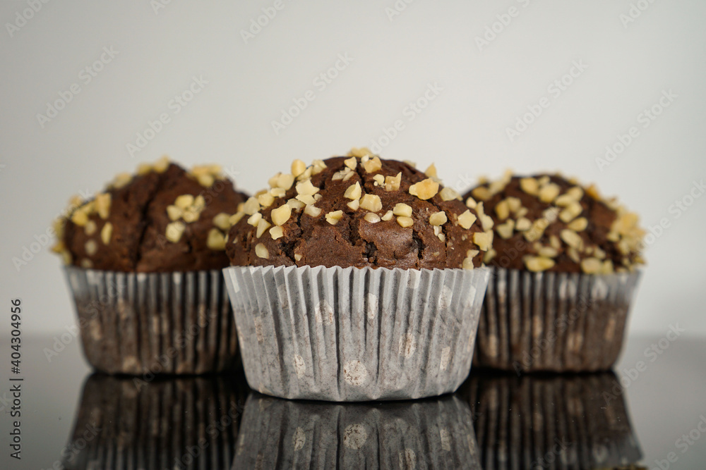 three chocolate muffins in front of a white background three chocolate muffins in front of a white background