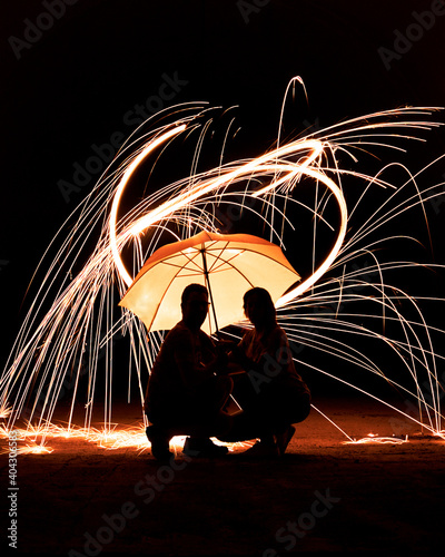 Konstfotografi Couple under the umbrella with burning steel rain.