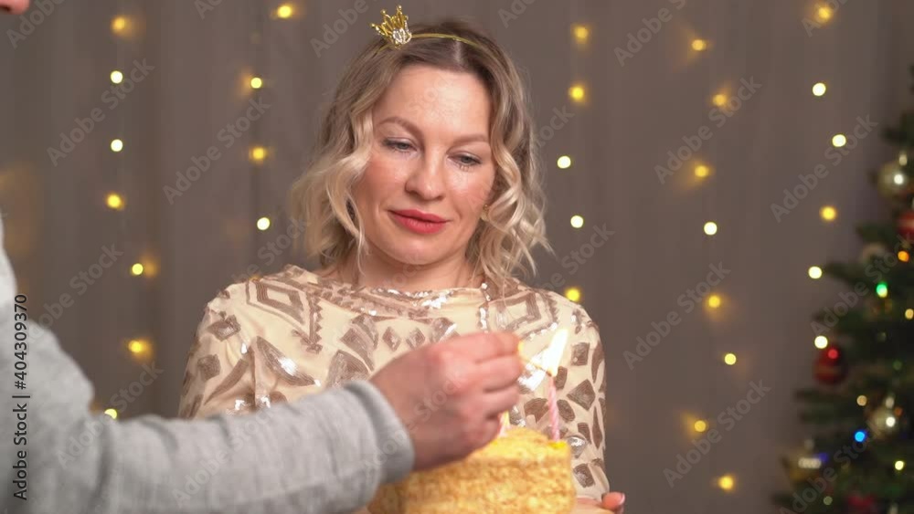 Beautiful blonde woman in a small crown on her head with a birthday cake and candles. tradition to make a wish and blow out the fire. It's a party. Beautiful blonde woman in a small crown on her head with a birthday cake and candles. tradition to make a wish and blow out the fire. It's a party.
