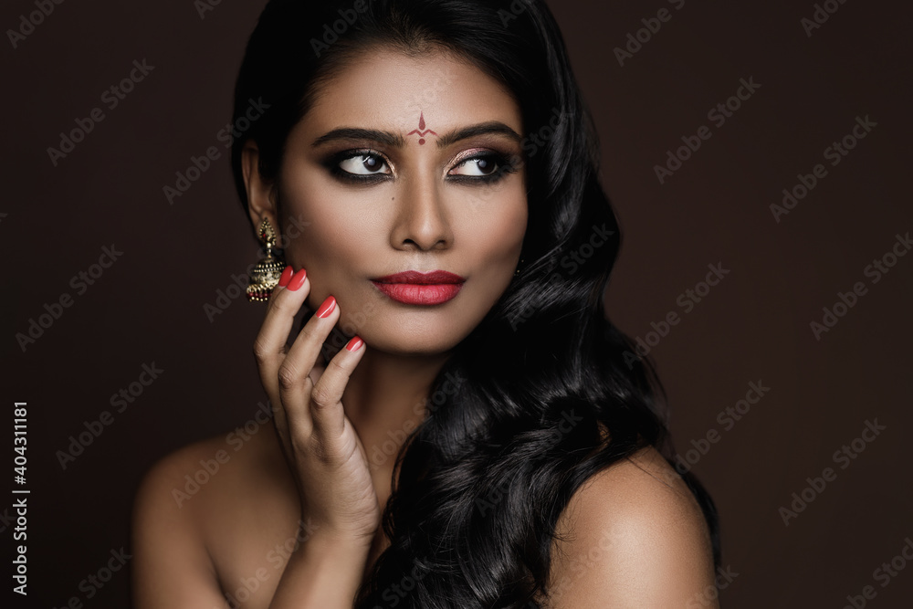 Portrait of Indian woman with beautiful makeup and hairstyle on brown background Portrait of Indian woman with beautiful makeup and hairstyle on brown background