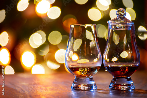 Glasses of scotch whisky served in bar in Edinburgh, Scotland, UK and pasry lights on background