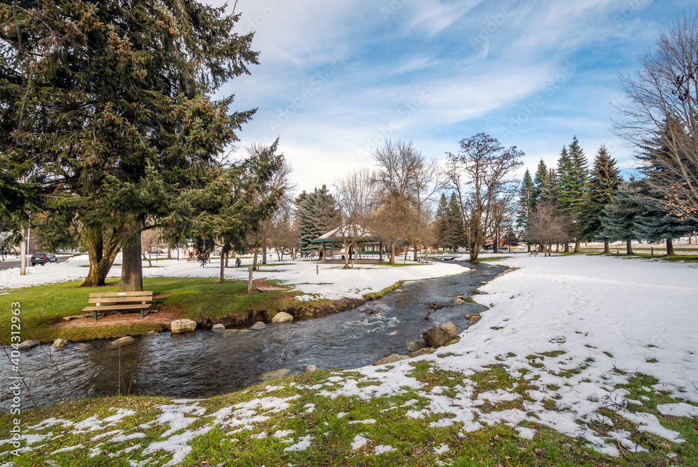 A small creek runs through the small public park with snow during winter at Rathdrum, Idaho USA. A small creek runs through the small public park with snow during winter at Rathdrum, Idaho USA.