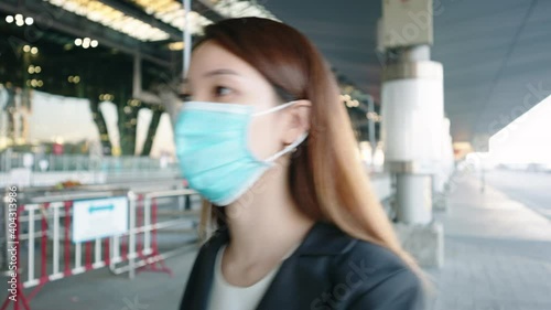 Asian businesswoman wearing face mask before entering an airport photo