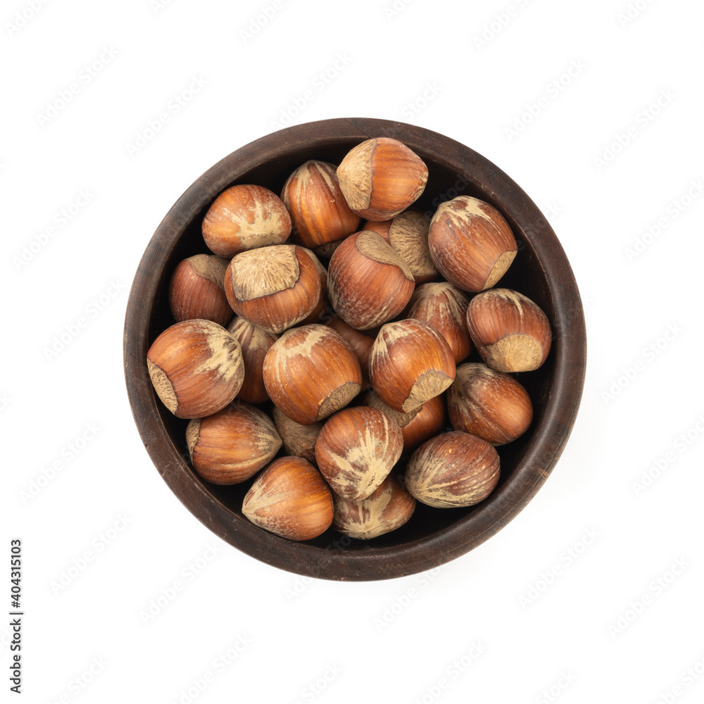 Hazelnuts on a old wooden bowl isolated over white background Hazelnuts on a old wooden bowl isolated over white background