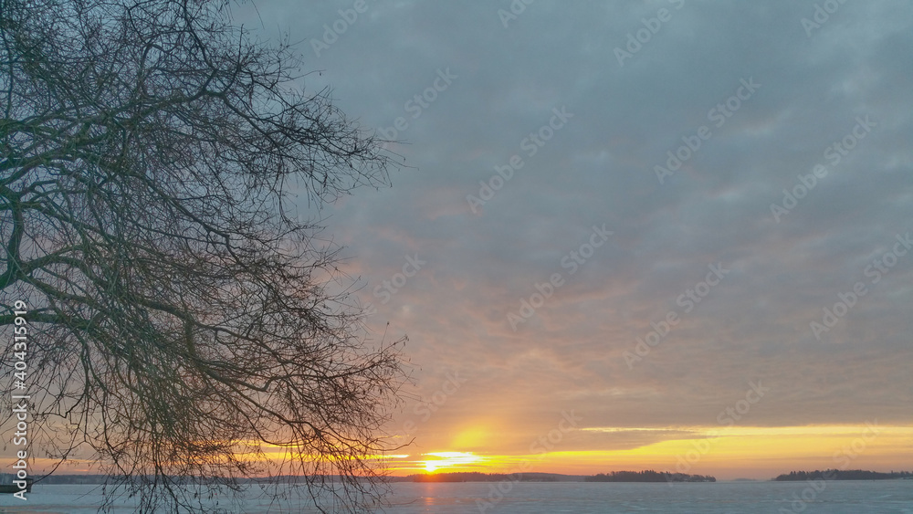 Sunrise in a cold winter morning with a icy lake in background Sunrise in a cold winter morning with a icy lake in background