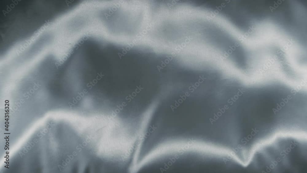White silky fabric waving and flowing vertically in slow motion.