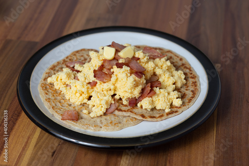 Scrambled eggs and bacon on Derbyshire oatcakes angled view