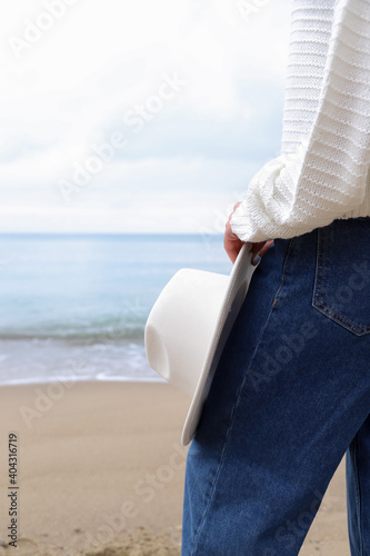 Girl with a white hat on the beach.
