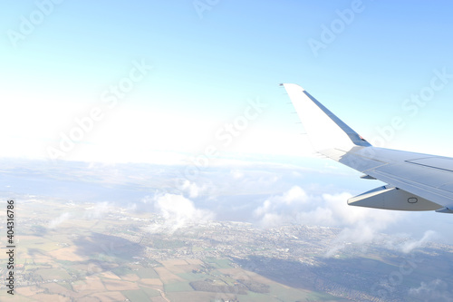 Beautiful horizon blue sky with white wing of airplane fiying above white clouds. View from airplane window