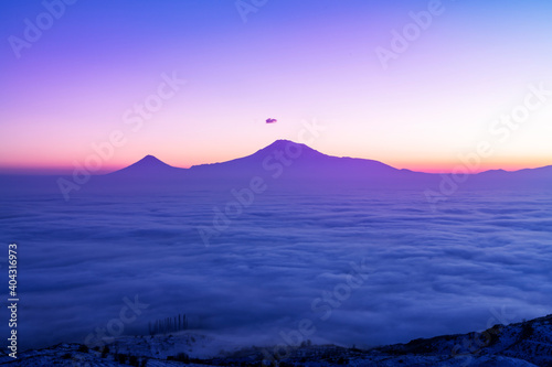 Beautiful sunset with long exposure clouds. The mountains in a clouds and fog. Ararat mountain.