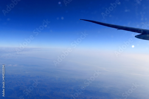 Beautiful horizon blue sky with airplane wing fiying on the air. Viewed from airplane window.