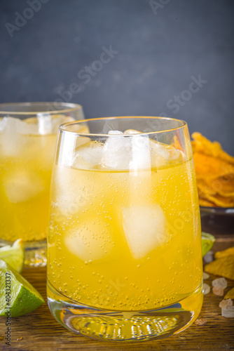 Summer boozy citrus cocktail, citrus margarita, tequila drink with salt and Mexican chips, Summer cold cocktail concept, copy space