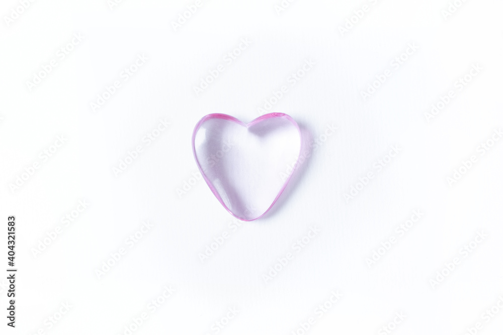 Valentine's day background with pink heart. Copy space. Shiny glass heart on white background.