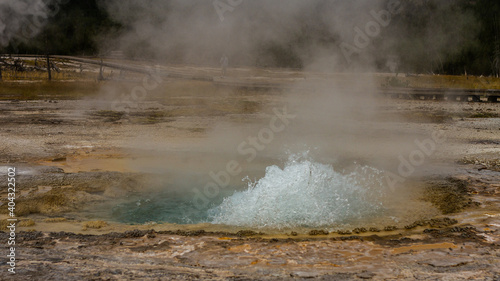 close up of small hot active gushing gayser in yellowstone national park in america