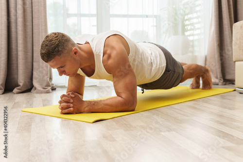 Man doing plank during intense home workout photo