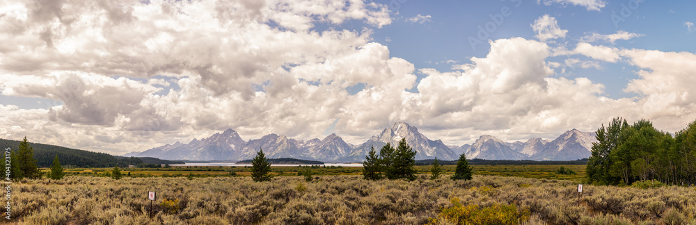 Panorama shot of snowy mountains in clouds of  Grand teton national park in america