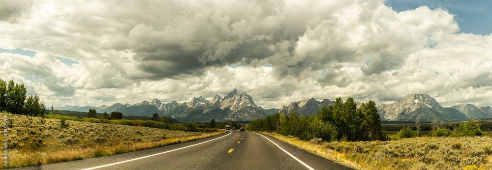 Wide shot of road goes to hills in grand teton national park in america