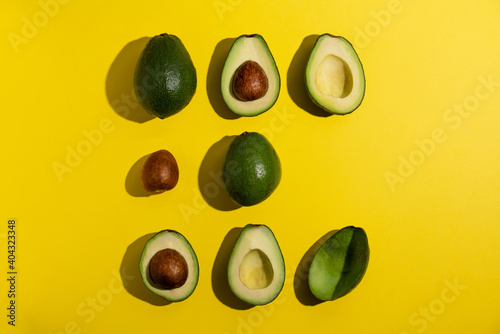 Multiple avocados on yellow background