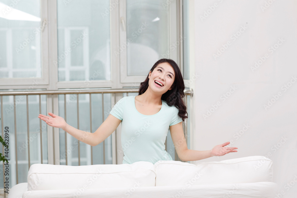 A Young woman standing behind a couch A Young woman standing behind a couch