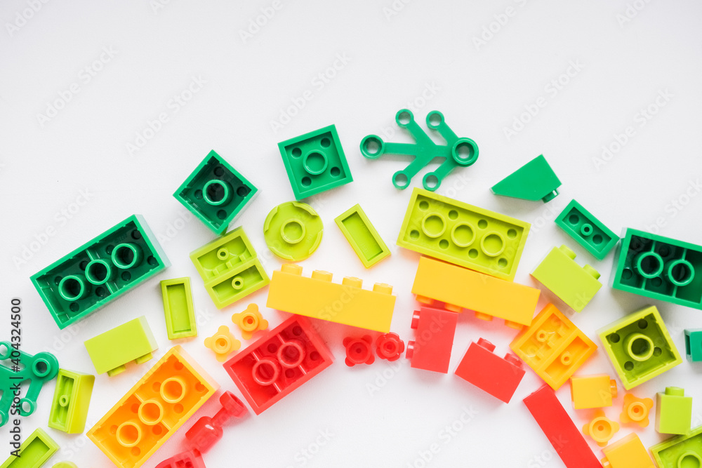 Developing children games frame. Colorful plastic bricks and blocks on white background ,top view ,space for text. Educational toy for children. Developing children games frame. Colorful plastic bricks and blocks on white background ,top view ,space for text. Educational toy for children.