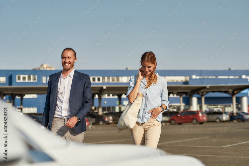 Smiling young man and woman with bags after shopping