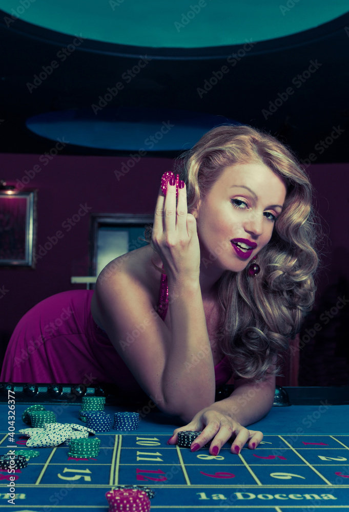 attractive blonde woman dressed in red enjoying her luck in the casino attractive blonde woman dressed in red enjoying her luck in the casino