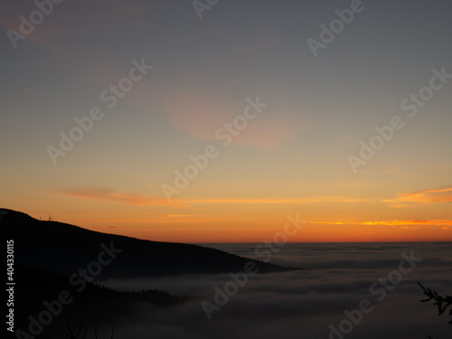 View from mountain range to the valley above fog and clouds at sunset, high altitude landscape,spruce trees,sun,blue sky,clouds, sunlight,temperature inversion. Jeseniky mountains,Czech Republic.  . © Jansk