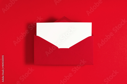Red envelope with empty white paper on red background. Flat lay, top view, copy space © prime1001
