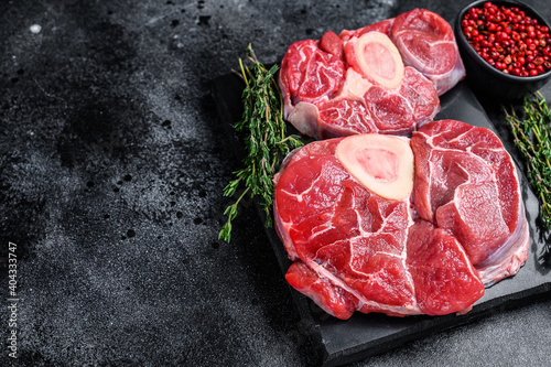 Raw beef meat osso buco shank steak,  italian ossobuco. Black background. Top view. Copy space
