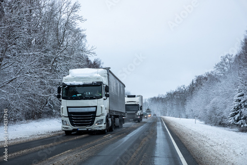 Trucks on a country road after a snowfall