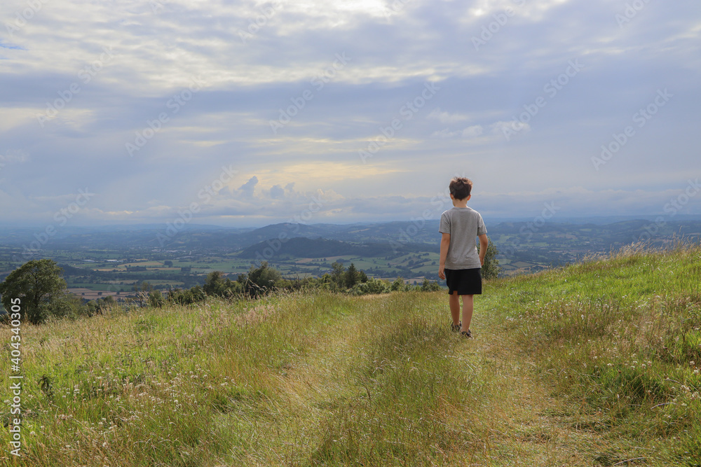 Boy walking across the hills in the countryside